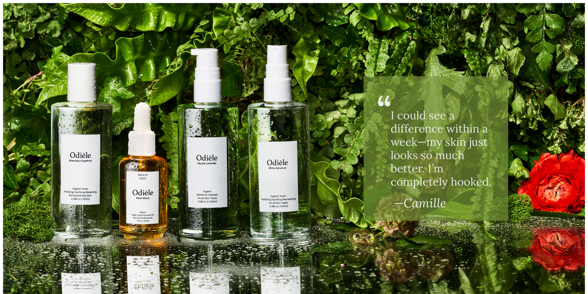 Four Oxide skincare bottles arranged on a glossy reflective surface against a lush green leaf background. The set includes two clear bottles with white caps, one amber dropper bottle with a white cap, and one clear spray bottle with a white pump.